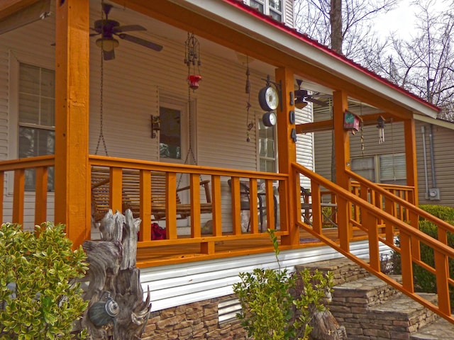 wooden terrace featuring covered porch and ceiling fan