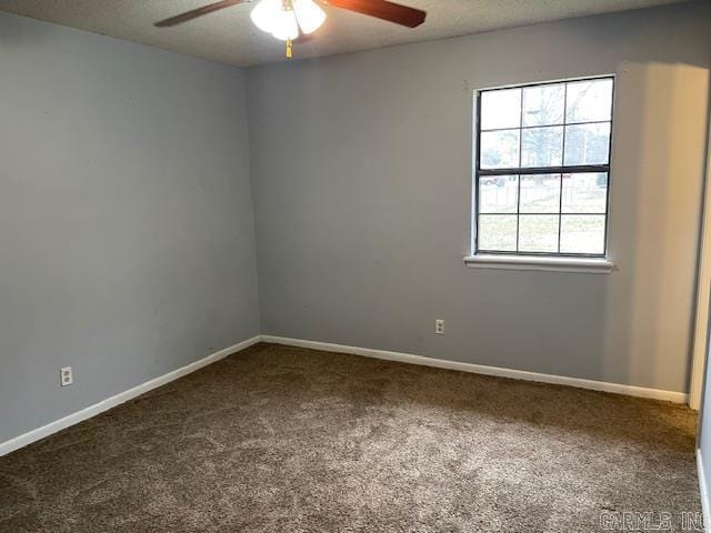 carpeted spare room featuring a textured ceiling, baseboards, and a ceiling fan