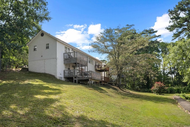 back of house with a wooden deck and a lawn