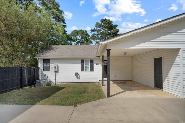 view of property exterior with a lawn, fence, cooling unit, concrete driveway, and a carport