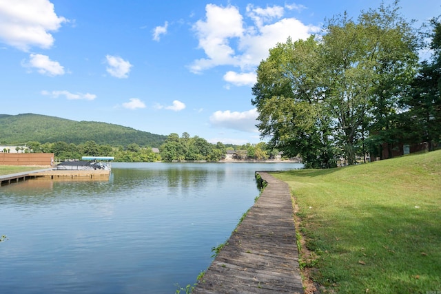 view of dock with a yard and a water and mountain view