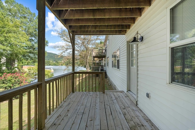 deck with stairway and a water view