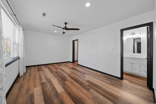 unfurnished bedroom featuring visible vents, baseboards, recessed lighting, wood finished floors, and a sink