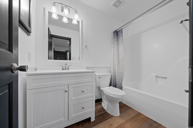 full bath featuring visible vents, toilet, wood finished floors, wainscoting, and vanity