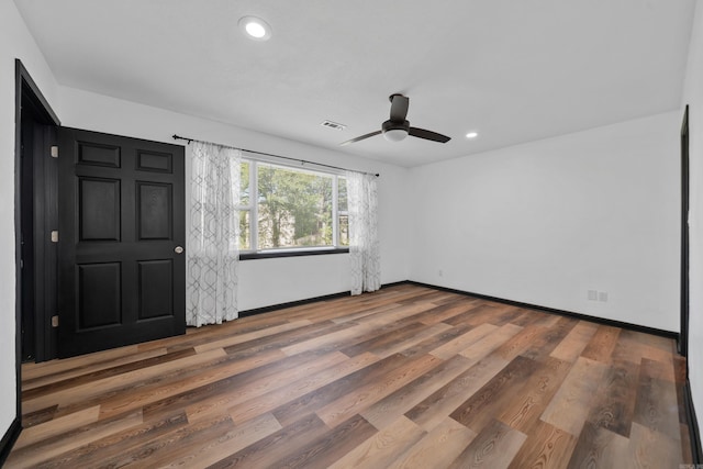 empty room with recessed lighting, visible vents, baseboards, and wood finished floors