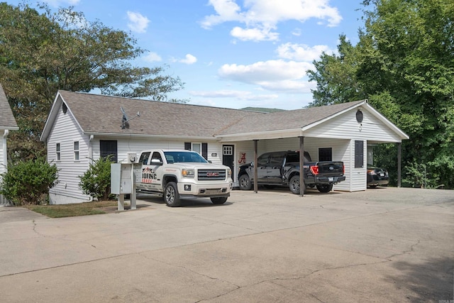 single story home with a carport and a shingled roof