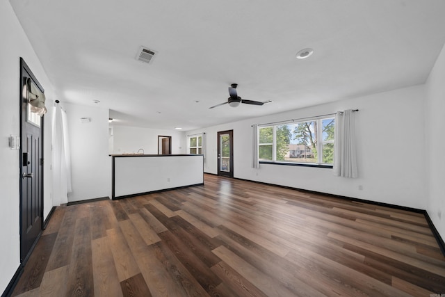 unfurnished living room featuring visible vents, baseboards, wood finished floors, and a ceiling fan