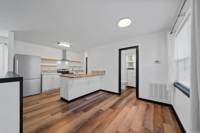 kitchen with visible vents, open shelves, appliances with stainless steel finishes, a peninsula, and dark wood-style flooring