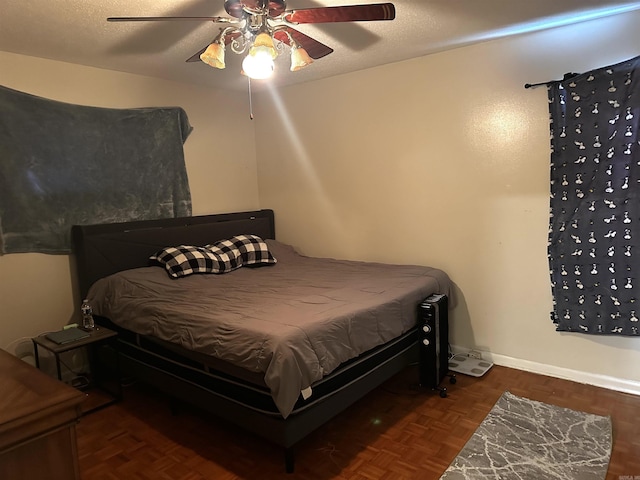 bedroom featuring baseboards, a textured ceiling, and a ceiling fan