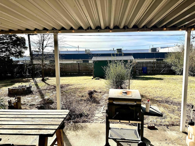 view of yard with an outdoor structure, a fenced backyard, and a fire pit