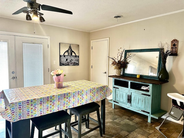 dining space with visible vents, stone finish flooring, ornamental molding, french doors, and a textured ceiling