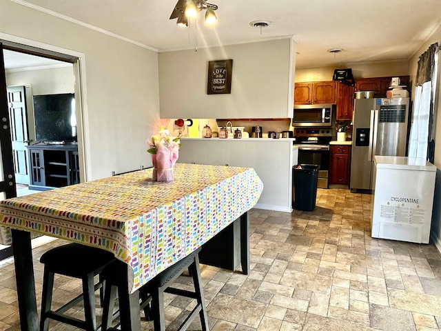 dining area featuring visible vents, crown molding, and stone finish floor