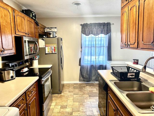 kitchen with a sink, stone finish flooring, appliances with stainless steel finishes, and light countertops