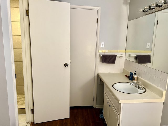 bathroom featuring tile walls, wood finished floors, and vanity