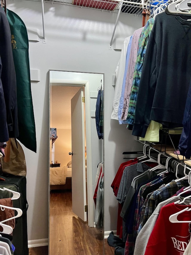 walk in closet with wood finished floors