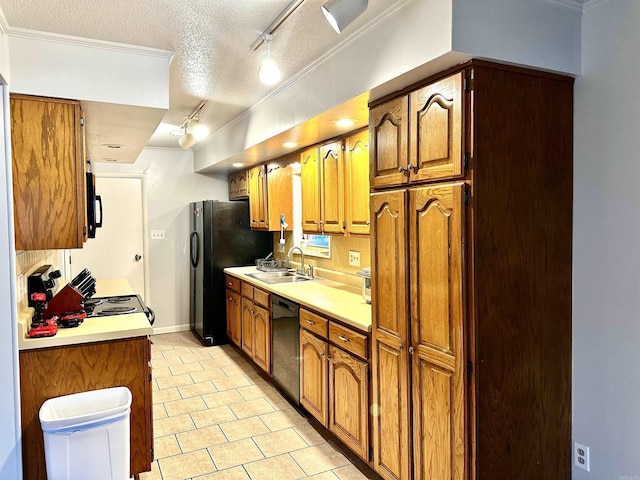 kitchen featuring brown cabinets, a textured ceiling, black appliances, and a sink