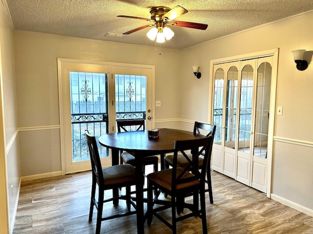 dining area with plenty of natural light, crown molding, and wood finished floors