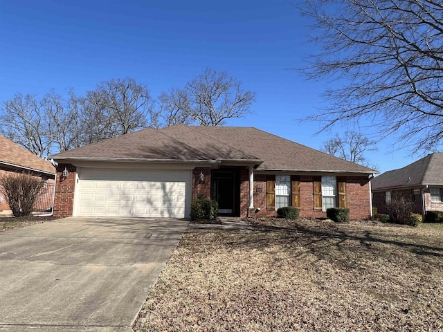 ranch-style house featuring brick siding, a garage, concrete driveway, and roof with shingles