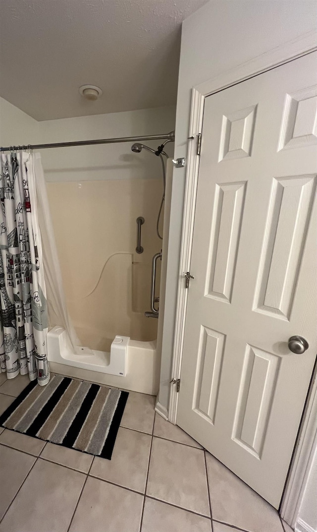 bathroom with a shower with shower curtain and tile patterned floors