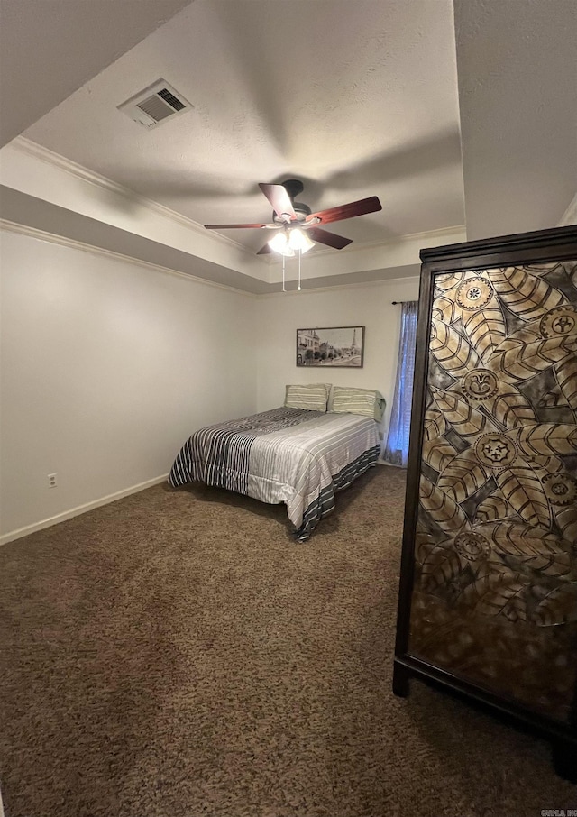 unfurnished bedroom featuring carpet, visible vents, baseboards, a tray ceiling, and crown molding