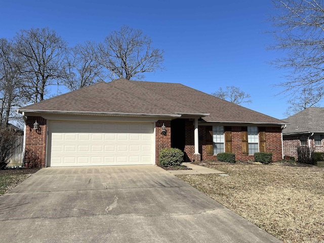 view of front of house featuring an attached garage, brick siding, driveway, and a shingled roof