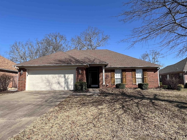 single story home with brick siding, roof with shingles, concrete driveway, and an attached garage