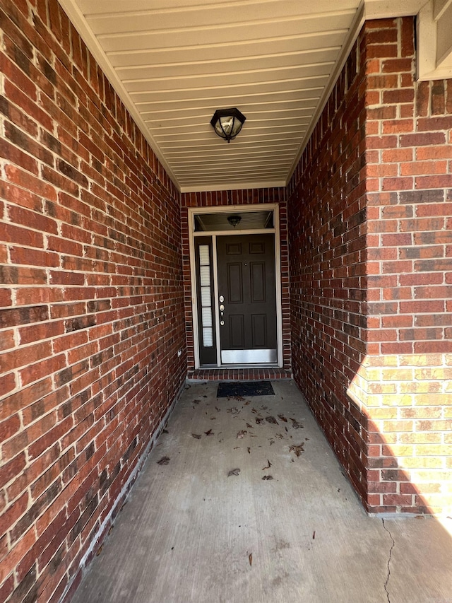 doorway to property featuring brick siding