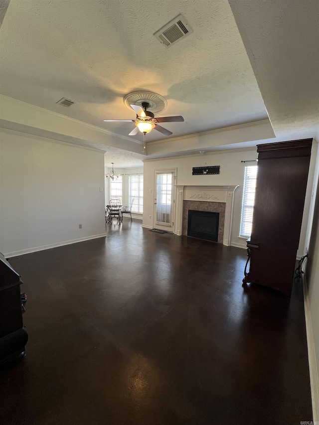 unfurnished living room with visible vents, a textured ceiling, a raised ceiling, and baseboards