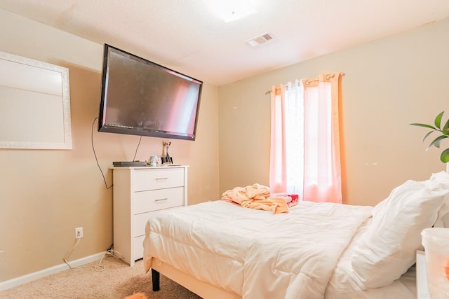 bedroom featuring visible vents, baseboards, and light colored carpet