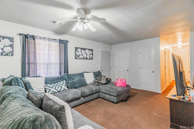 living room with visible vents, baseboards, ceiling fan, carpet, and a textured ceiling