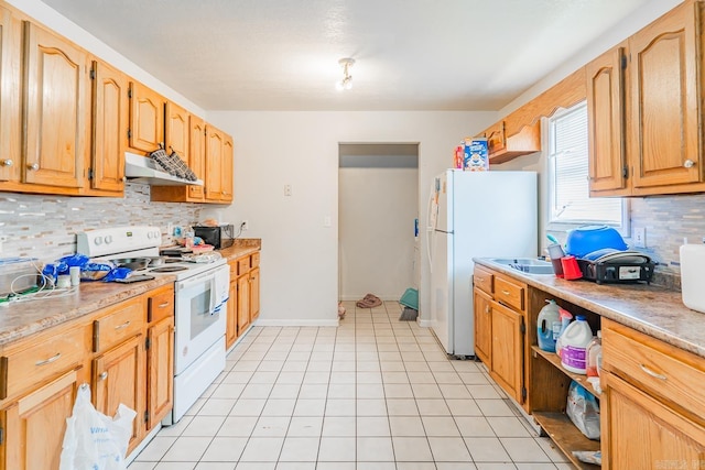 kitchen featuring white appliances, light tile patterned floors, decorative backsplash, light countertops, and under cabinet range hood