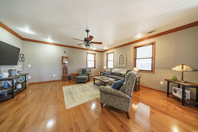 living room featuring light wood-type flooring, visible vents, a ceiling fan, crown molding, and baseboards