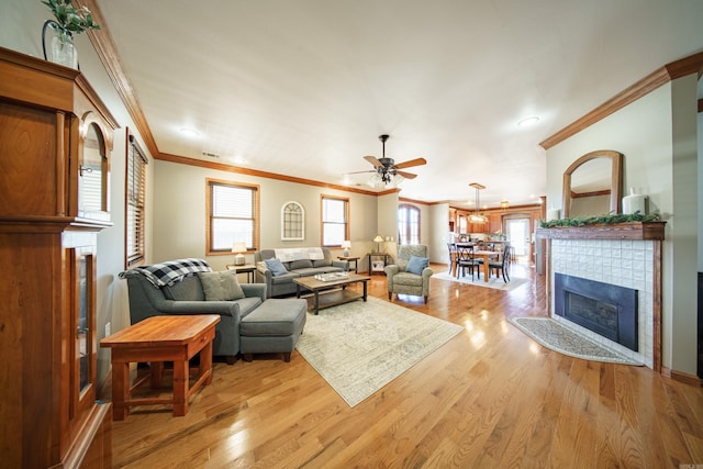 living area with a healthy amount of sunlight, light wood-type flooring, and a tile fireplace