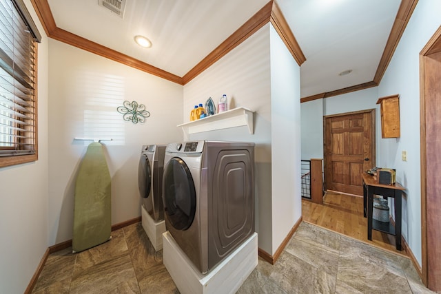 laundry room with visible vents, washer and clothes dryer, crown molding, baseboards, and laundry area