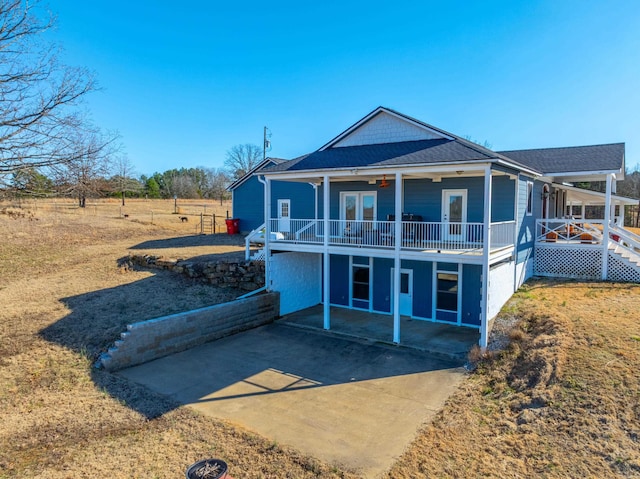 back of property with a carport and roof with shingles