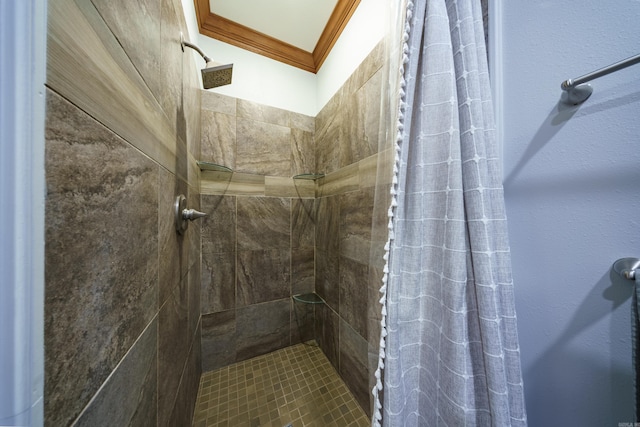 full bath with a tile shower and crown molding