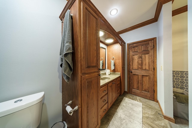 bathroom featuring baseboards, toilet, ornamental molding, and vanity