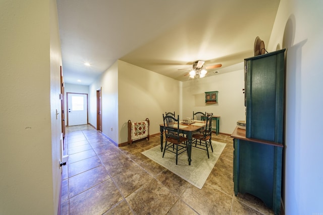 dining room with a ceiling fan and baseboards