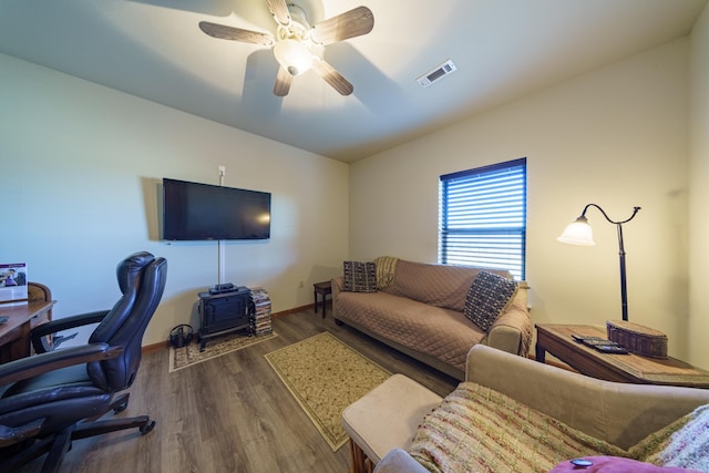 interior space with ceiling fan, visible vents, baseboards, and wood finished floors