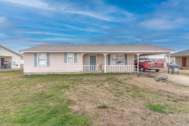 ranch-style home featuring a porch, a carport, a front yard, and driveway