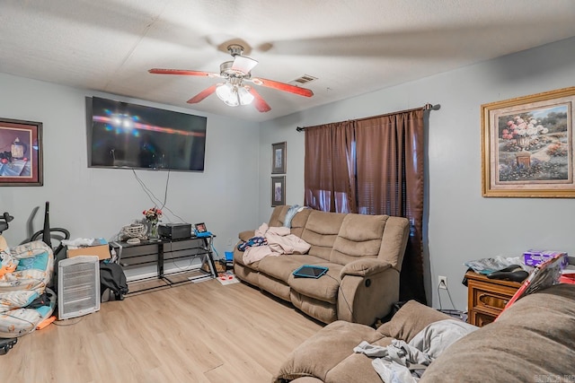 living area featuring visible vents, wood finished floors, and a ceiling fan