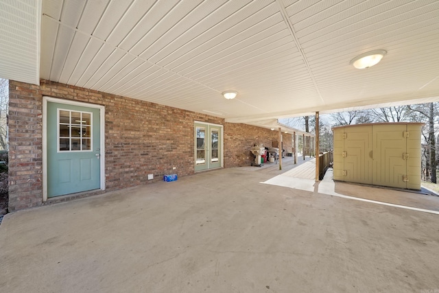 view of patio with french doors, a storage unit, and an outdoor structure