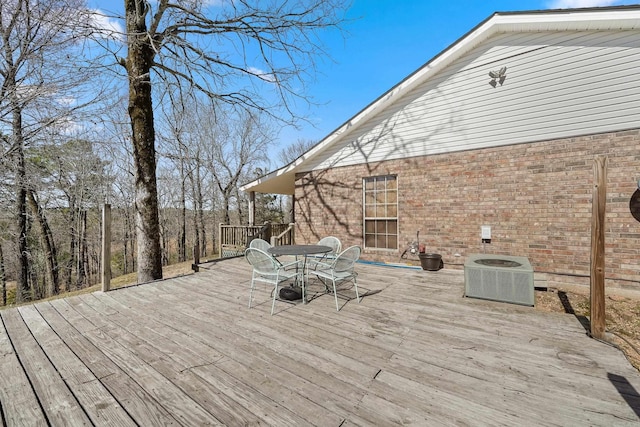 wooden terrace featuring central air condition unit and outdoor dining area