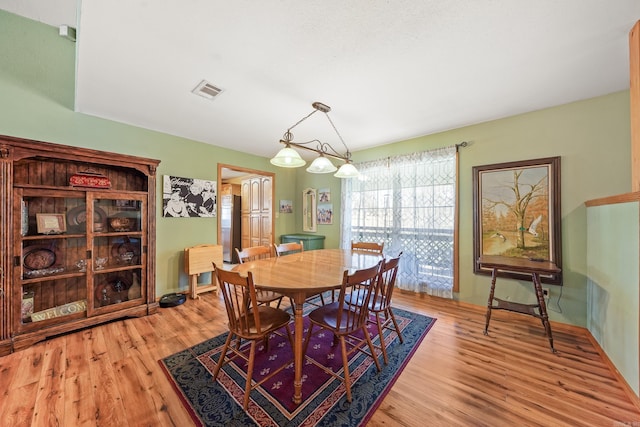 dining area with visible vents and light wood-style floors