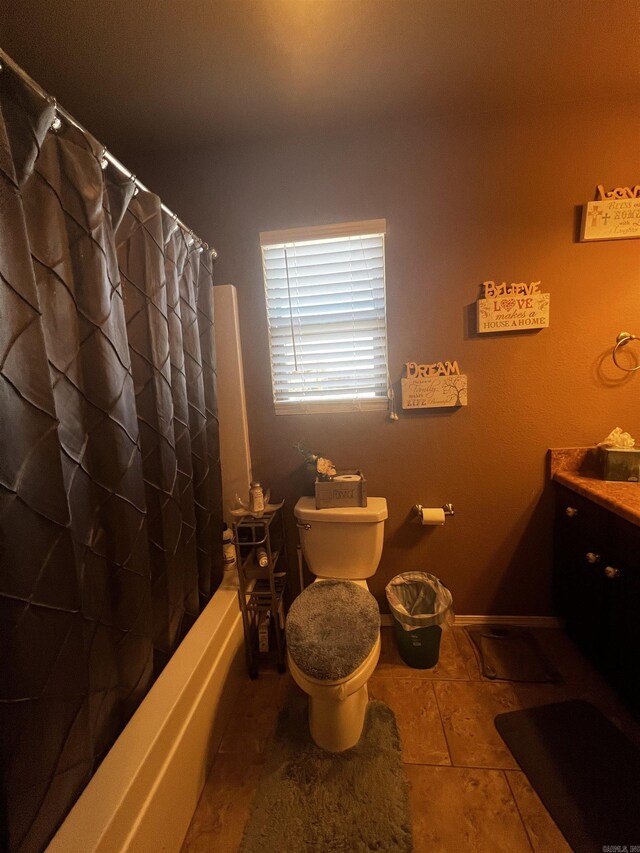 bathroom featuring baseboards, toilet, vanity, and shower / bath combo with shower curtain