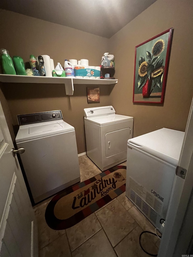 clothes washing area with separate washer and dryer, light tile patterned flooring, and laundry area