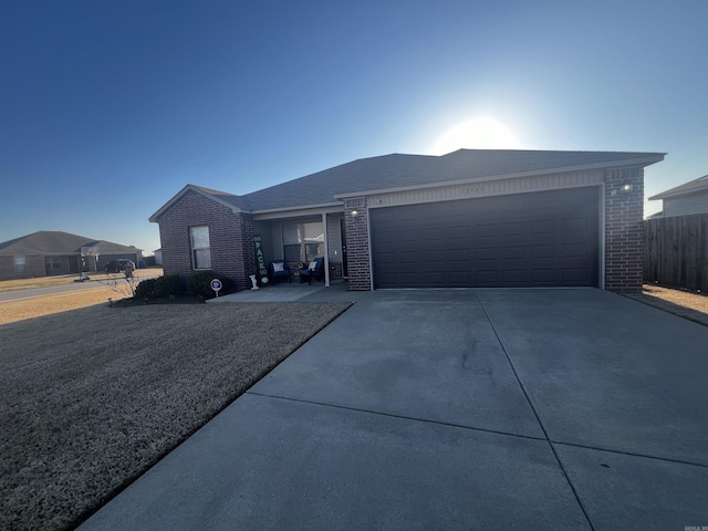 single story home featuring brick siding, an attached garage, and concrete driveway