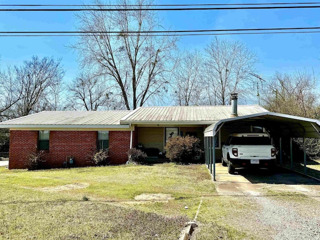 ranch-style house featuring a front lawn, driveway, a detached carport, metal roof, and brick siding