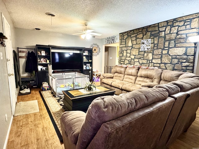 living area with a textured ceiling, a ceiling fan, and wood finished floors