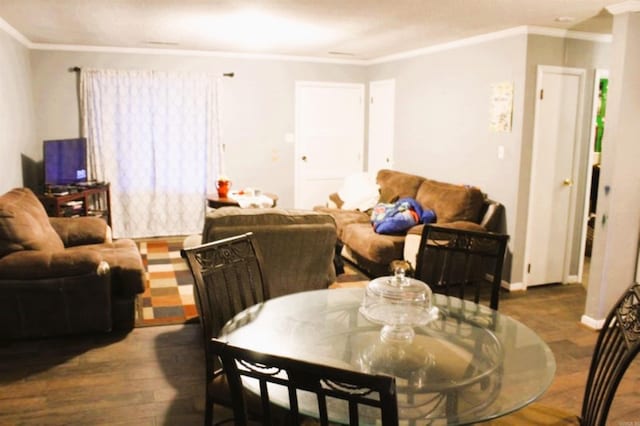 dining room with wood finished floors, baseboards, and ornamental molding